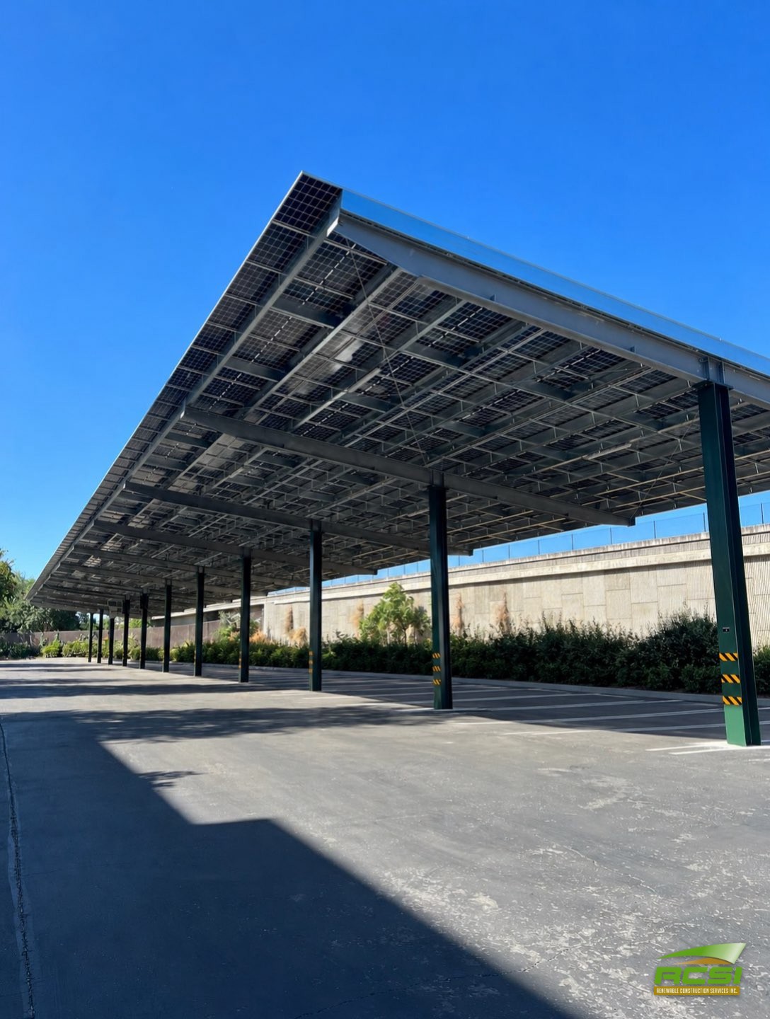RCSI steel solar carport canopy over a parking lot under a blue sky